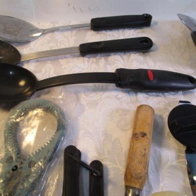 Sale Photo Thumbnail #139: Corn cob holders, new meat thermometer, pizza cutter, can opener, measuring spoons, nut cracker & picks, baster, spatula, 6 serving spoons, tongs, ladle, bottle openers, ice pick, bottle opener, watermelon slicer, tupperware cleaner, rubber spatulas