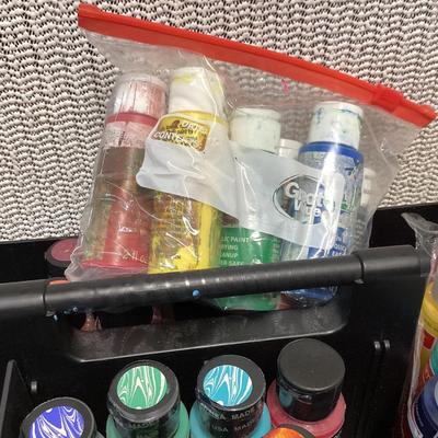 Craft paints- the ones inside the container appear to be full, the ones outside the container are partially full