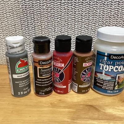 Craft paints- the ones inside the container appear to be full, the ones outside the container are partially full