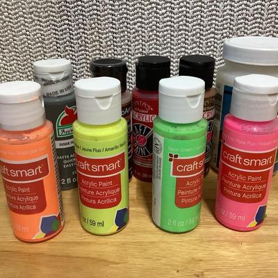 Craft paints- the ones inside the container appear to be full, the ones outside the container are partially full