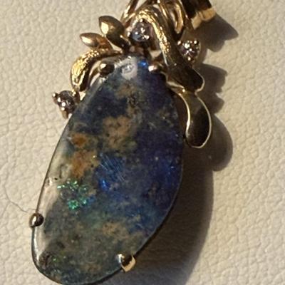 Sale Photo Thumbnail #239: Black or boulder opal, set in 14K setting with accent diamonds
Freeform shape, the opal is 11.4mm x 21.4mm. x 3.6 mm, about 4 carats
Beautiful color in the stone.