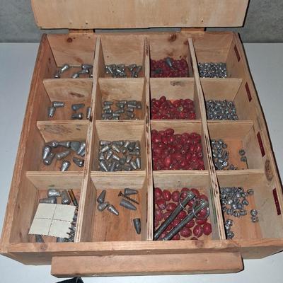A SECTIONED BOX OF VARIOUS SIZE FISHING SINKERS AND SOME LURES IN A HOLDER