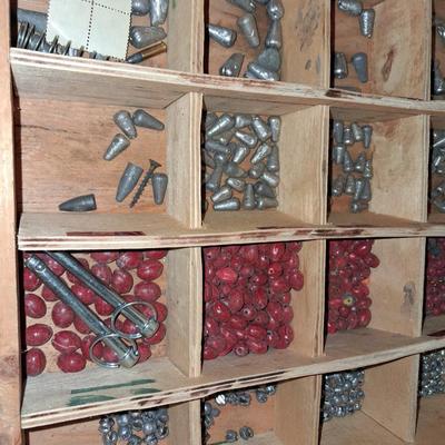 A SECTIONED BOX OF VARIOUS SIZE FISHING SINKERS AND SOME LURES IN A HOLDER
