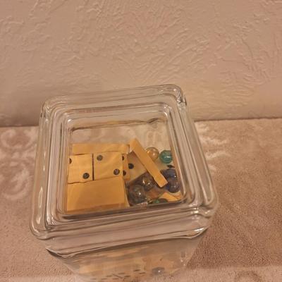 glass jar with 2 sets of dominoes and various glass beads or marbles
