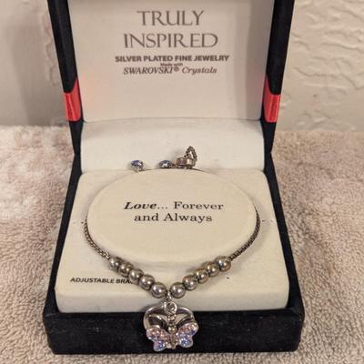 "Truly Inspired" silver-plated adjustable bracelet with a butterfly charm made with Swarovski® crystals.