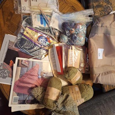 assortment of knitting or crocheting supplies, needles, little bit of yard and a few patterns