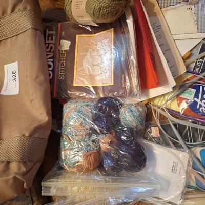 assortment of knitting or crocheting supplies, needles, little bit of yard and a few patterns