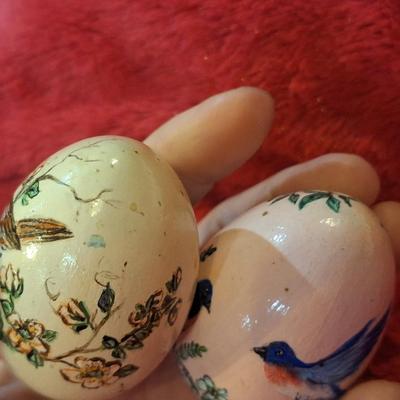 two hand painted wooden eggs with birds and flowers