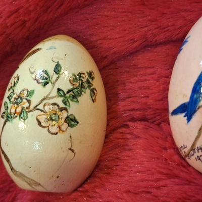 two hand painted wooden eggs with birds and flowers