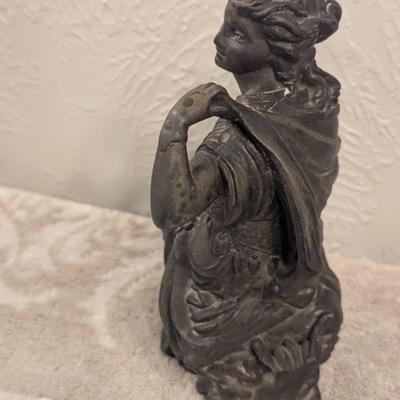 cast metal spelter clock topper of woman seated, Greek goddess maybe? Diana Artemis or Pandora? We aren't sure.