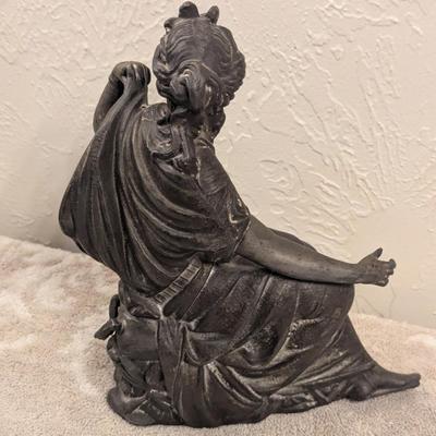 cast metal spelter clock topper of woman seated, Greek goddess maybe? Diana Artemis or Pandora? We aren't sure.