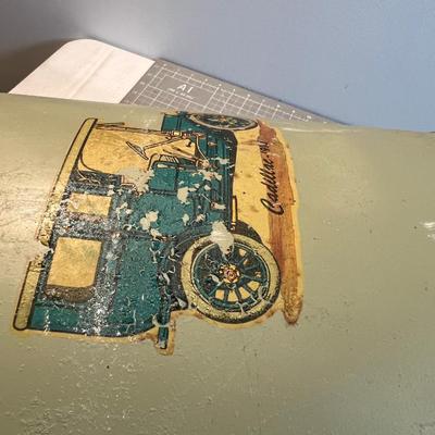 Old Milk Can that has been Painted and has Car Stickers on it. 