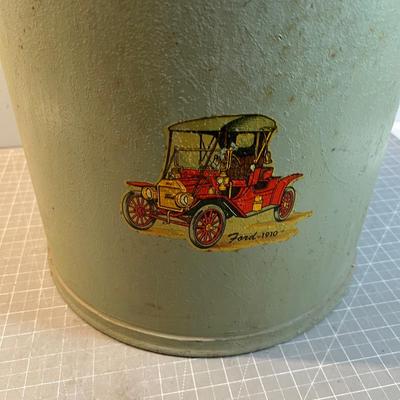 Old Milk Can that has been Painted and has Car Stickers on it. 