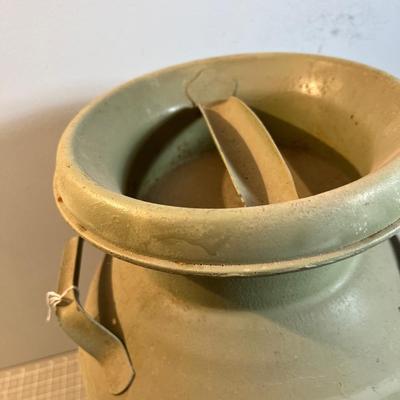 Old Milk Can that has been Painted and has Car Stickers on it. 