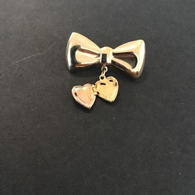 Sale Photo Thumbnail #186: Vintage gold tone bow brooch with dangling heart locket 
Please see attached pictures