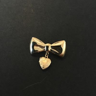 Sale Photo Thumbnail #184: Vintage gold tone bow brooch with dangling heart locket 
Please see attached pictures