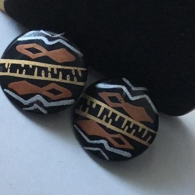 Handmade round black button stud earrings with an ethnic or tribal inspired geometric pattern in white brown/orange