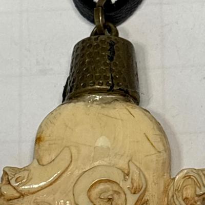 Bone carved pendant on leather necklace