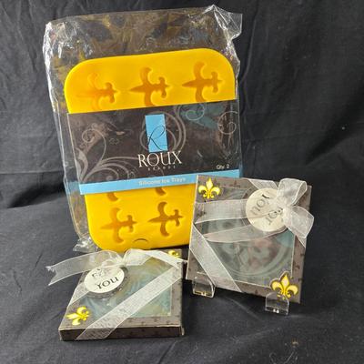 Sale Photo Thumbnail #377: This is s grouping of Fleur de Lis Items that could be used for entertaining.  It includes 2 etched glass coasters and a package of 2 silicone ice cube trays.  All items are new and never used.  The final picture is of the coaster outside of it's box.