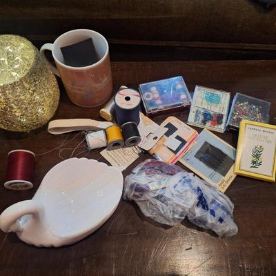 crafty things, sewing kits, thread, coffee cup, candle holder with battery mini Led string lights and swan dish.