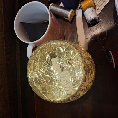 crafty things, sewing kits, thread, coffee cup, candle holder with battery mini Led string lights and swan dish.