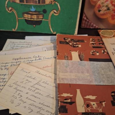 vintage cookboox and pamplets, the stoneware book has been heavily used- it has a bend to it.