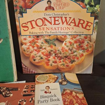 vintage cookboox and pamplets, the stoneware book has been heavily used- it has a bend to it.