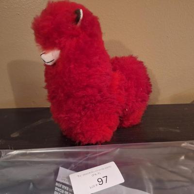 This is a red, handmade alpaca fur plush toy. 