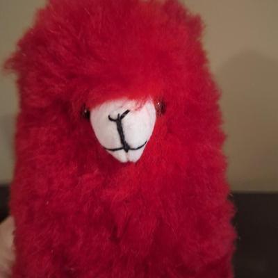 This is a red, handmade alpaca fur plush toy. 