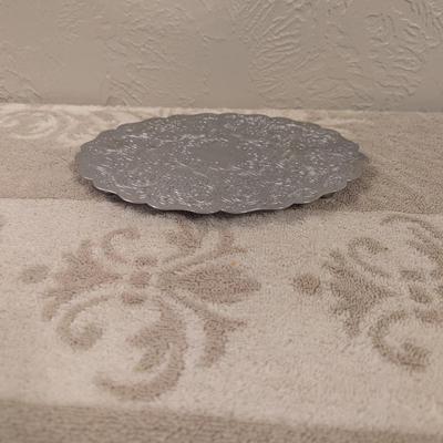 silver toned metal trivet with floral scroll pattern