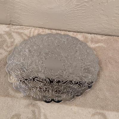 silver toned metal trivet with floral scroll pattern