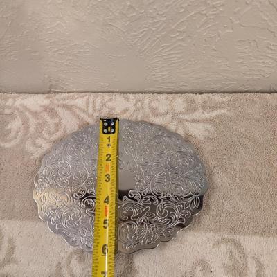 silver toned metal trivet with floral scroll pattern