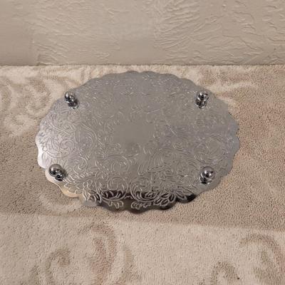 silver toned metal trivet with floral scroll pattern