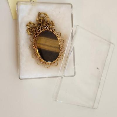 Sale Photo Thumbnail #386: This lot is for a Monet Onyx Pendant in 12KGF Mounting.  This handsome necklace sports a nice sliced onyx stone.  The chain is marked Monet but appears to be a gold-toned metal.