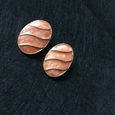 Oval clip on earrings with a coral colored enamel gold tone rope design