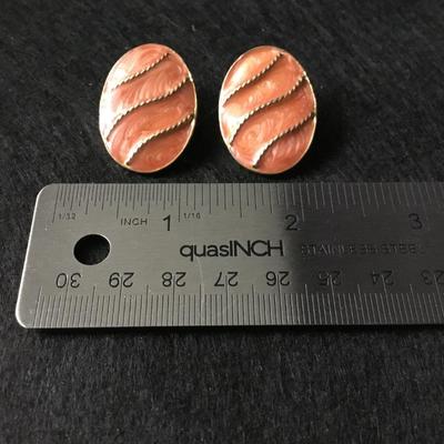 Oval clip on earrings with a coral colored enamel gold tone rope design