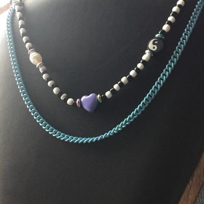 Layered, beaded, and chain necklace featuring a Purple Heart charm