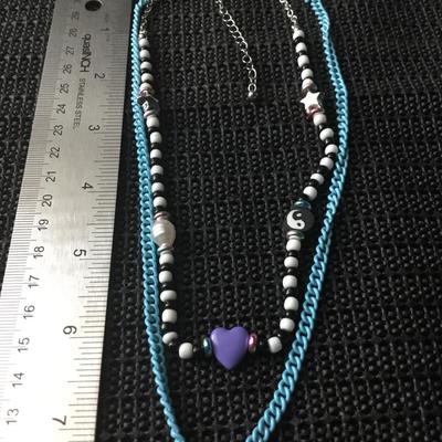 Layered, beaded, and chain necklace featuring a Purple Heart charm