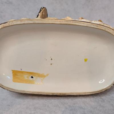 Sale Photo Thumbnail #221: Norleans Japan Porcelain Figurine 
Depicts man sitting down w/ a hat, pipe and book and a woman holding a basket 
7x8x4