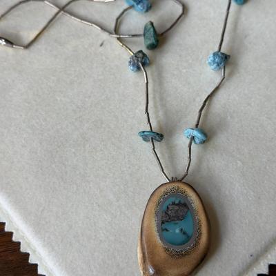 Sale Photo Thumbnail #386: Liquid Silver with turquoise nuggets on the 18" chain.  The turquoise stone is encased in silver and inlaid into the antler.  
What a conversation piece!