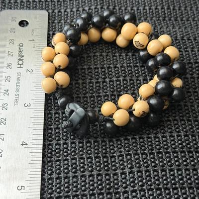 This is a handmade dual-strand beaded bracelet likely made of ebony wood and white sandalwood like beads.