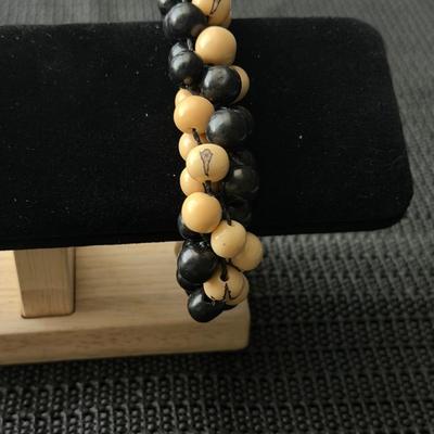 This is a handmade dual-strand beaded bracelet likely made of ebony wood and white sandalwood like beads.