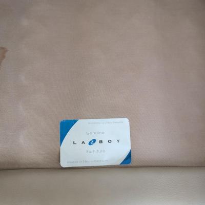 Sale Photo Thumbnail #7: Nice Lazy Boy Sofa, taupe in color, no tears or stains on the leather. The stain underneath the cushion is a water stain from a drink.