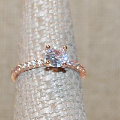 Size 7 Rose Gold 4 Prong Round Clear Main Stone Ring with 8 Accent Stone on Each Side on a Rose Gold Band (2.0g)