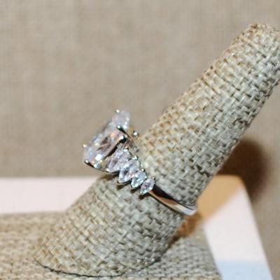 Size 8 Large Oval Clear Stone Ring with 8 Diamond Shape Side Accents on a Silver Tone Band (5.0g)