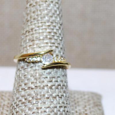 Size 8 Overlap Style Setting Ring with Small Main Stone & Side Accents on a Gold Tone Band (2.2g)