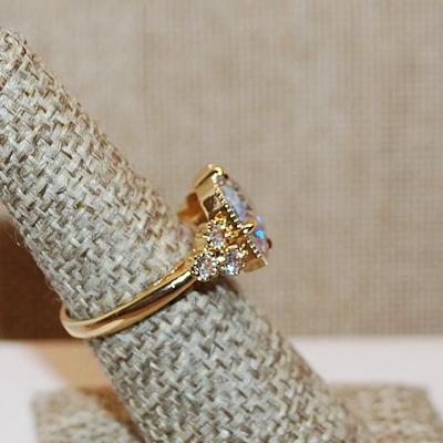 Size 7 Large Beveled Clear Glass Style Stone Ring with Triple Stone Side Accents on a Gold Tone Band (5.3g)