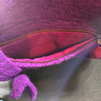 Sale Photo Thumbnail #463: This lot is for a Hand Made Felted Purple Purse.  It is actually darker than in the photo.  It is of a simple design with a felted box accent.  It has a zippered closer under the flap  It measures about 13-inches wide x 19-inches including straps,  It has