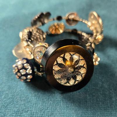 Sale Photo Thumbnail #522: This lot is for an Artist Hand Made Antique Button Bracelet. This is a very unique Hand Made Antique Button Bracelet by a local artist from St. James Art Fair.  It is a spiral wire design so it will fit anyone's wrist.  The old buttons have a wonderful lo