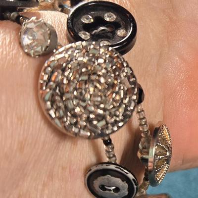 Sale Photo Thumbnail #526: This lot is for an Artist Hand Made Antique Button Bracelet. This is a very unique Hand Made Antique Button Bracelet by a local artist from St. James Art Fair.  It is a spiral wire design so it will fit anyone's wrist.  The old buttons have a wonderful lo
